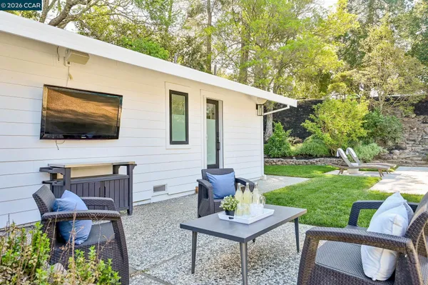 a view of a house with backyard and sitting area