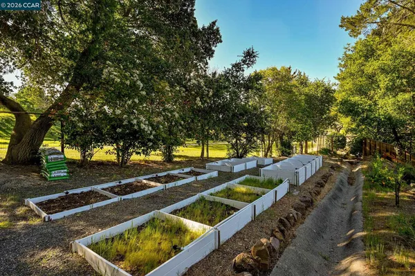 an aerial view of a house with garden space lake and mountain view in back