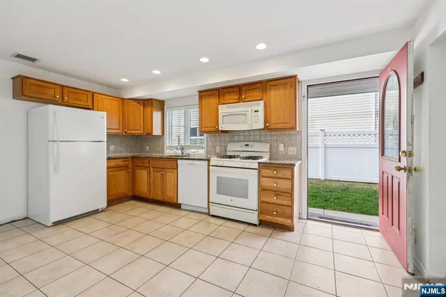 a kitchen with white cabinets and white appliances
