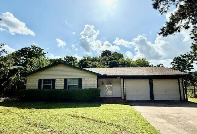 a front view of a house with a garden and yard