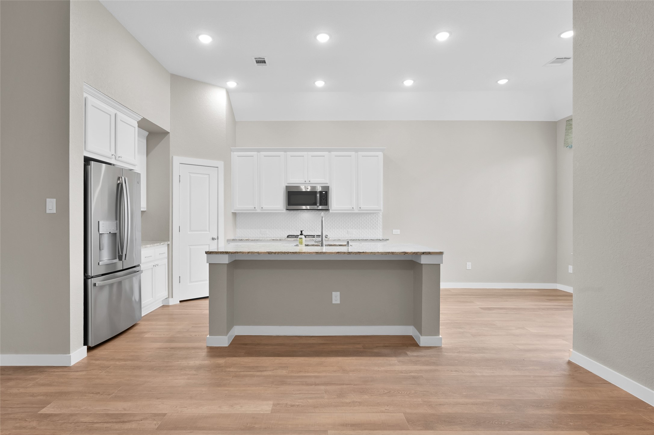 14960 Scarlet Branch Drive Conroe, TX 77302 - Photo 12 of 50 Bright kitchen with white cabinetry, granite countertops, stainless steel appliances, and a large island perfect for prep or seating. Clean and modern layout.
