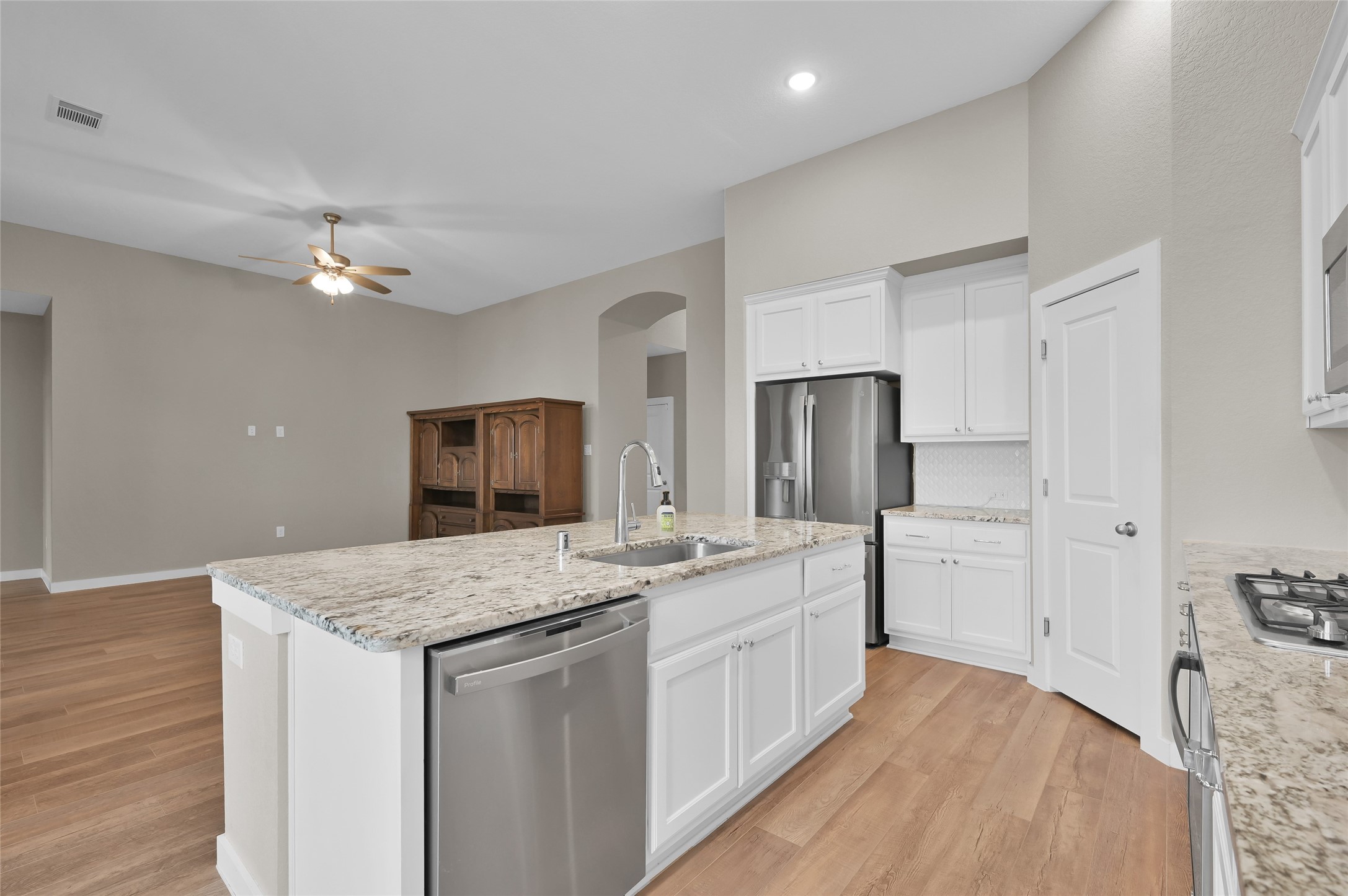 14960 Scarlet Branch Drive Conroe, TX 77302 - Photo 15 of 50 Granite island with undermount sink and stainless dishwasher. Full view of the open-concept layout with plenty of cabinet space and walk-in pantry access.