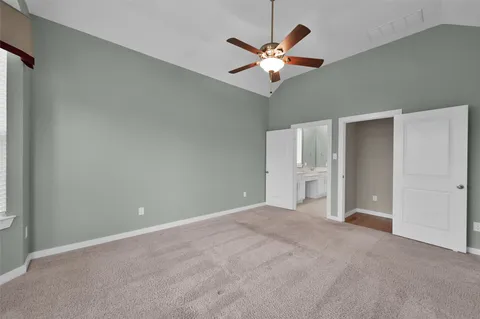a view of an empty room with wooden floor and a flat screen tv
