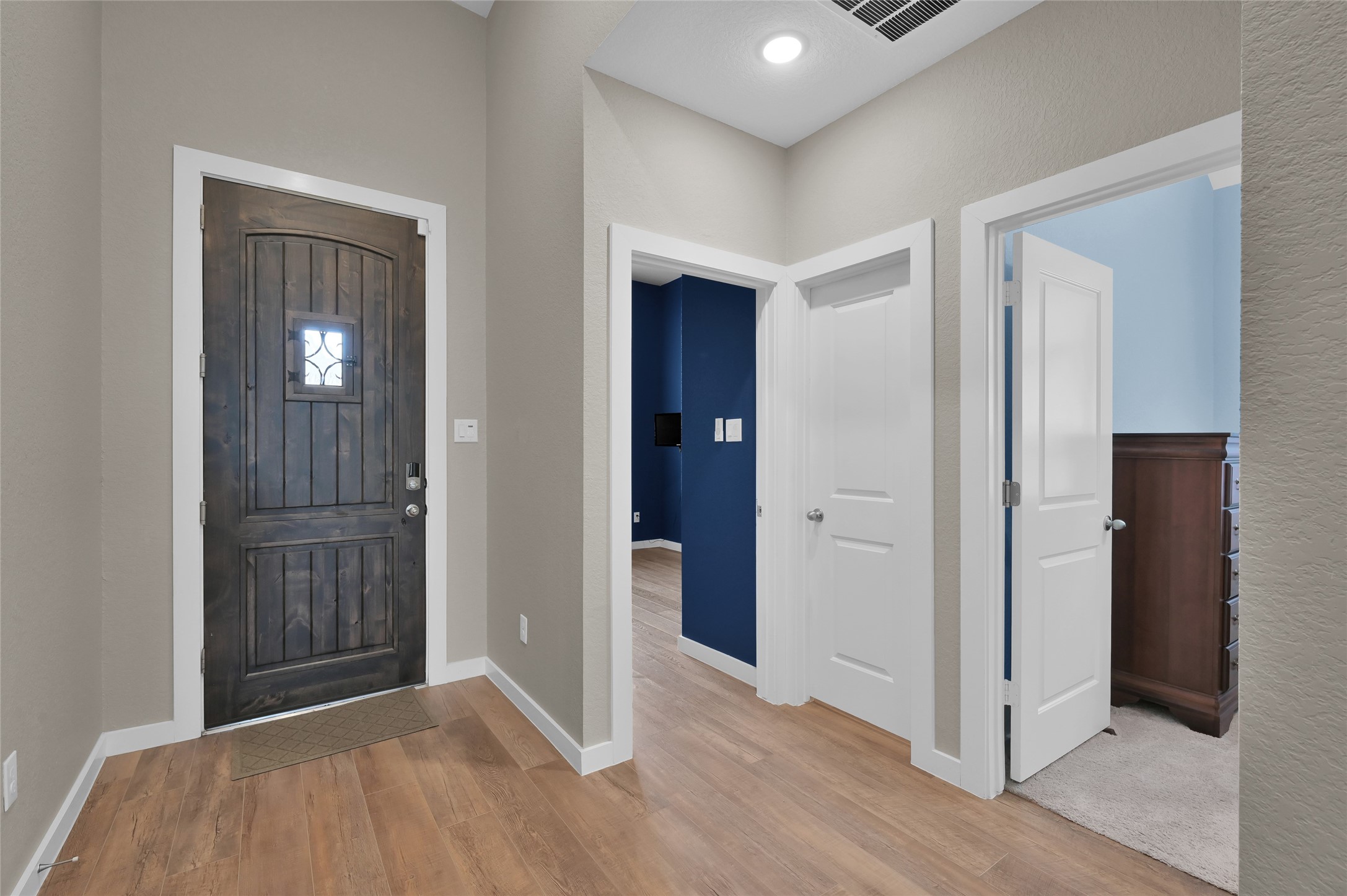14960 Scarlet Branch Drive Conroe, TX 77302 - Photo 25 of 50 Warm and inviting front entry with rich wood flooring and a charming dark-stained door that makes a strong first impression. Clean lines and neutral tones offer a fresh, modern feel.