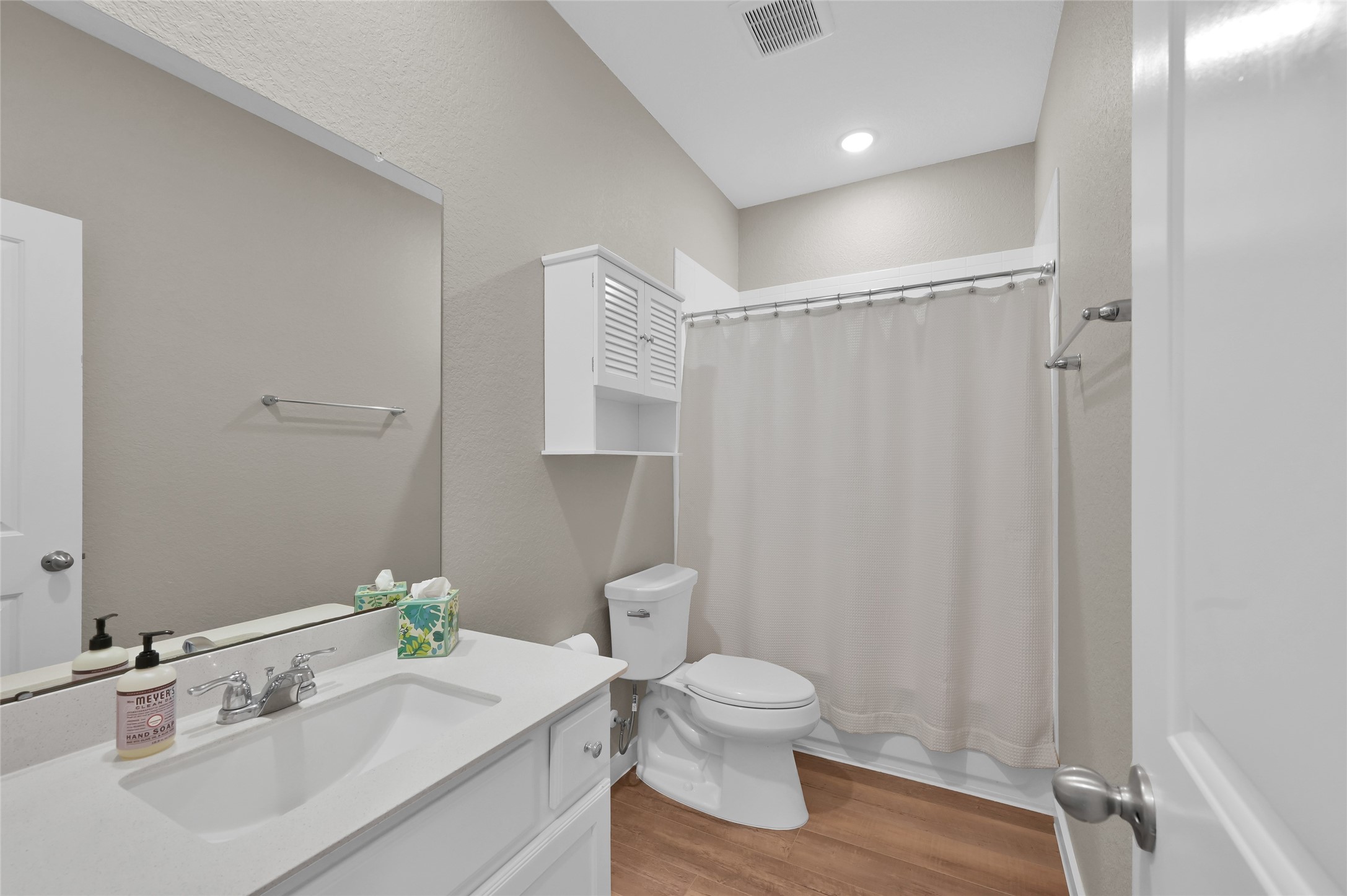 14960 Scarlet Branch Drive Conroe, TX 77302 - Photo 29 of 50 Bright and modern bathroom featuring a large vanity, overhead storage, and a tub/shower combo with a neutral curtain.