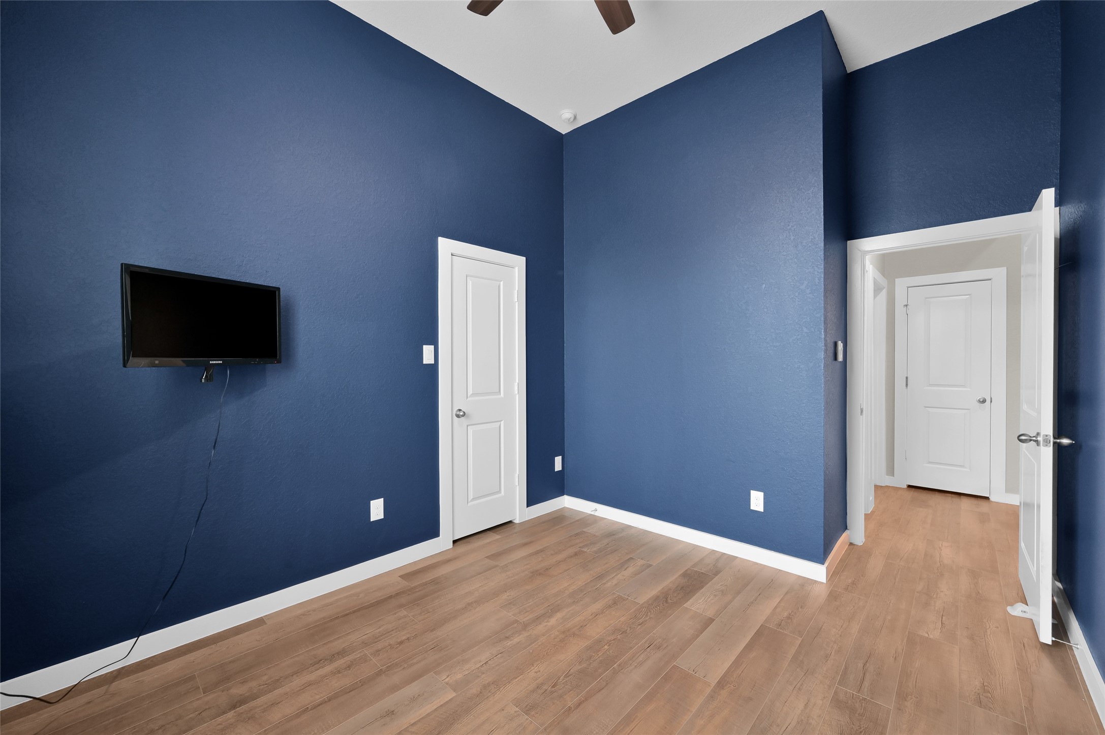 14960 Scarlet Branch Drive Conroe, TX 77302 - Photo 31 of 50 a view of an empty room with wooden floor and a flat screen tv