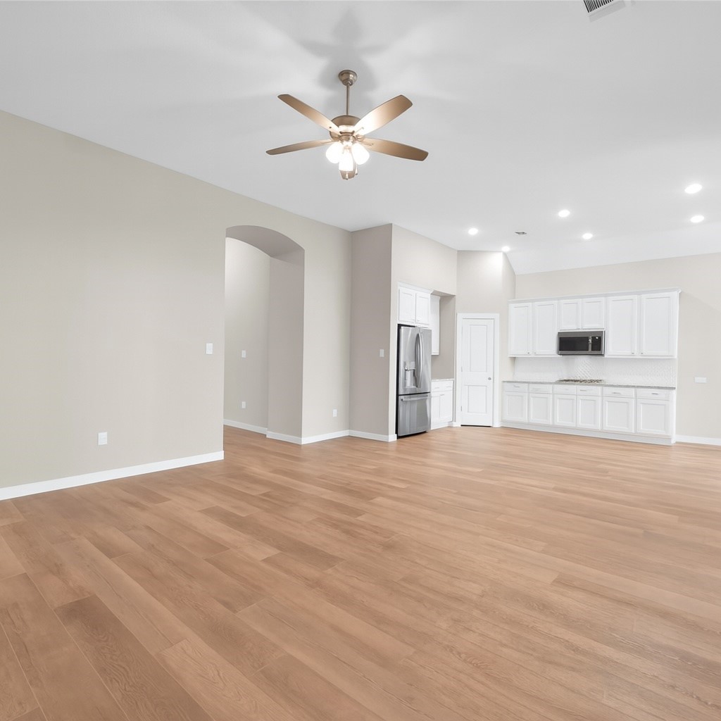14960 Scarlet Branch Drive Conroe, TX 77302 - Photo 10 of 50 Open living space with seamless flow into the kitchen. Features include wood-look flooring, recessed lighting, ceiling fan.