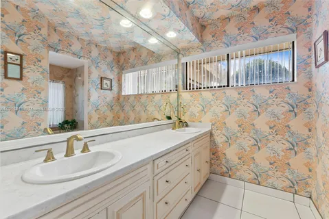 a bathroom with a granite countertop bathtub shower sink and toilet