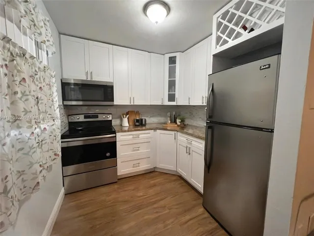 a kitchen with a refrigerator and a stove top oven