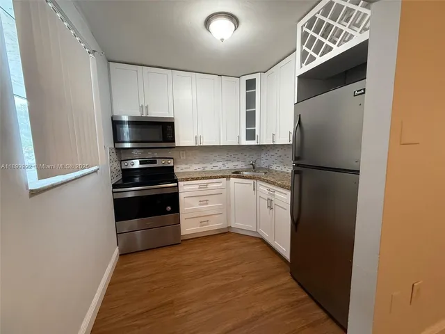 a kitchen with a refrigerator and a stove
