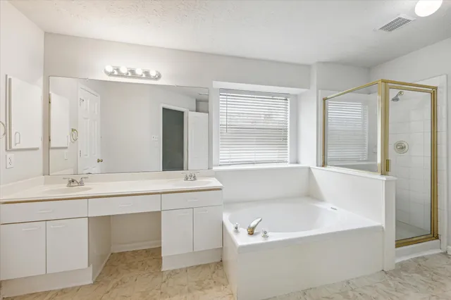 a bathroom with a tub sink and mirror