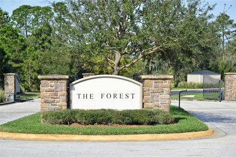 a sign of golf club on a wall under a tree