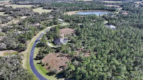 an aerial view of a house with a yard and outdoor seating