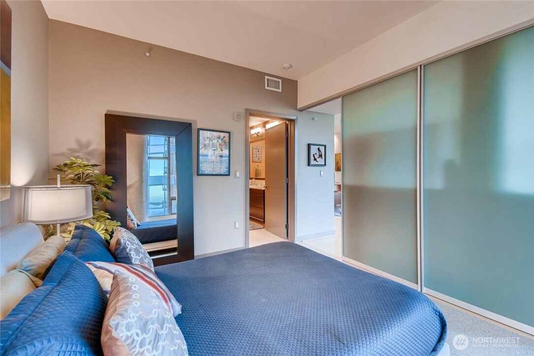 2033 2nd Avenue, Unit 1608 Seattle, WA 98121 - Photo 14 of 33 a bedroom with a bed and wooden floor