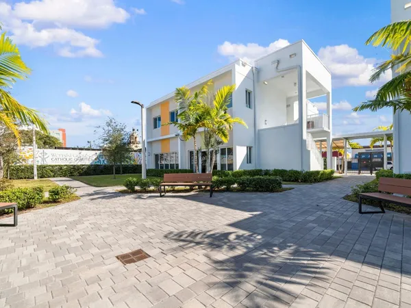 a view of a house with entertaining space and a car park in front of it