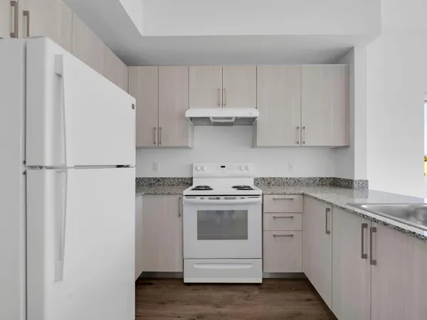 a kitchen with cabinets appliances and wooden floor