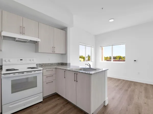 a kitchen with granite countertop white cabinets and white appliances