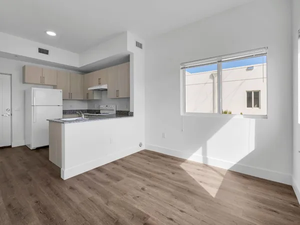 a kitchen with a refrigerator and white cabinets