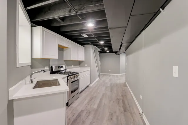 a kitchen that has a sink and a stove top oven