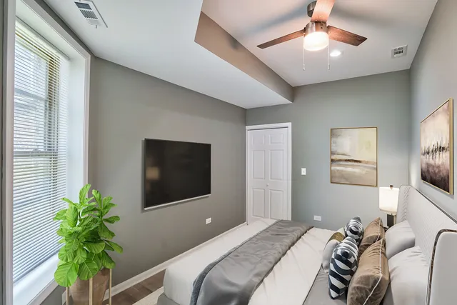 a bedroom with a bed and a potted plant
