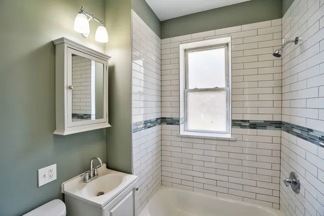 a bathroom with a sink a toilet and mirror