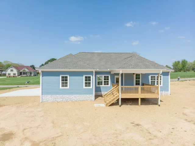 a view of a house with a yard and large tree