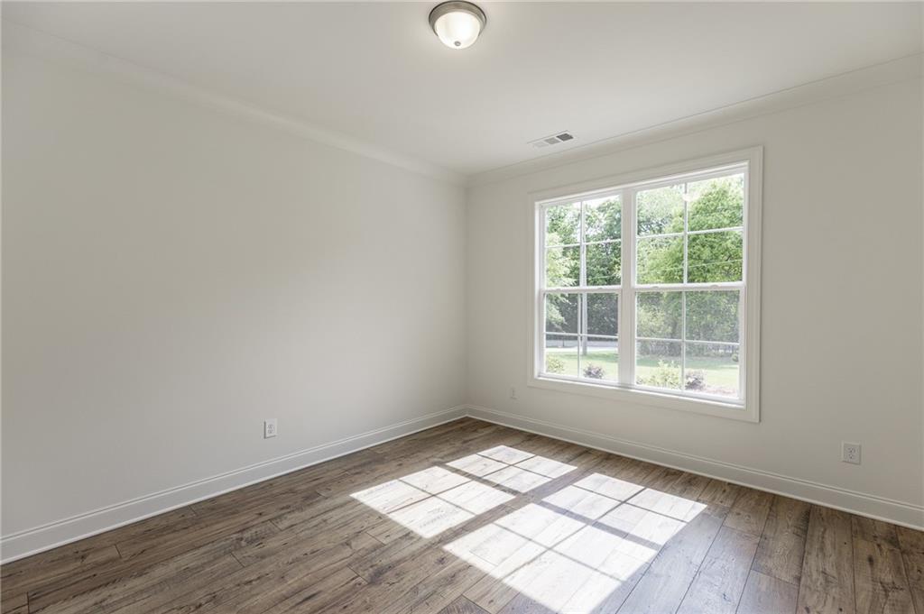 1210 Austin Road Winder, GA 30680 - Photo 7 of 56 an empty room with wooden floor and windows