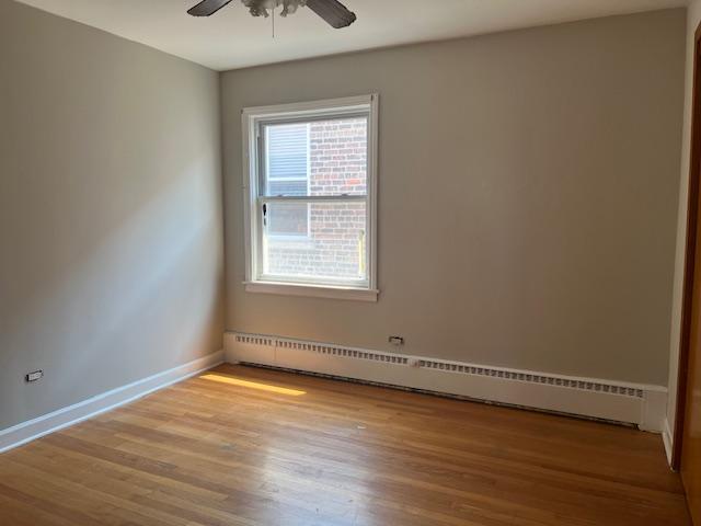 6100 South Kenneth Avenue, Unit 2 Chicago, IL 60629 - Photo 10 of 14 an empty room with wooden floor and windows