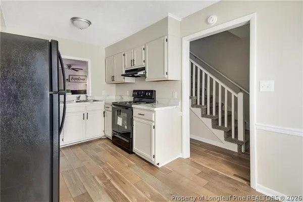 a kitchen with white cabinets and stainless steel appliances