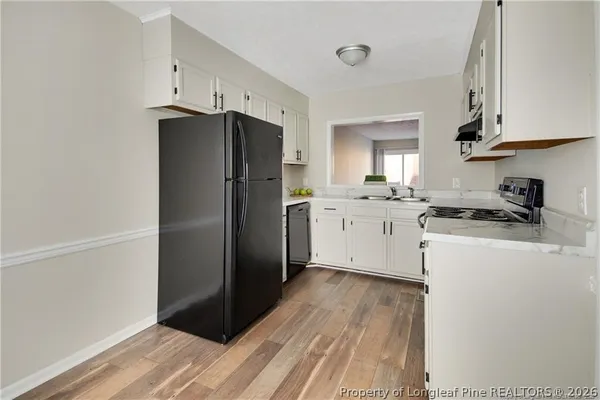 a kitchen with a refrigerator sink and cabinets