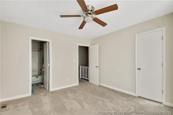 a view of an empty room and a ceiling fan