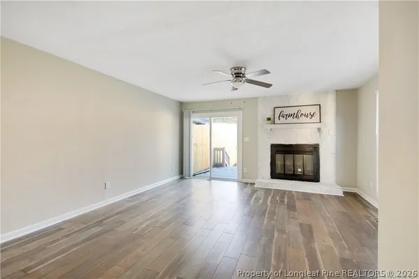 a view of an empty room with a fireplace and a window