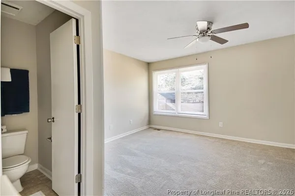 a bathroom with a toilet sink a mirror and a window