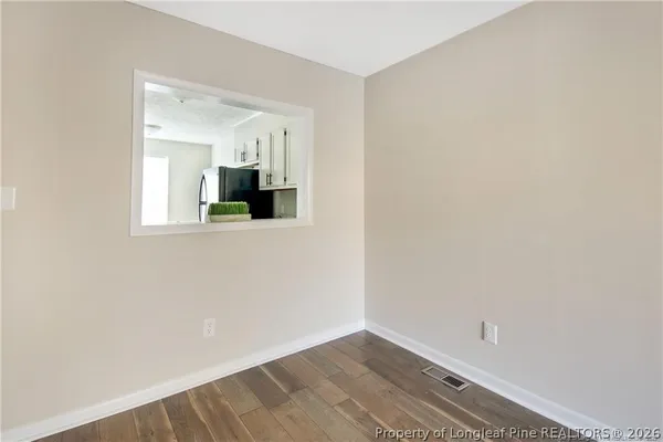 a view of a room with wooden floor and a ceiling fan