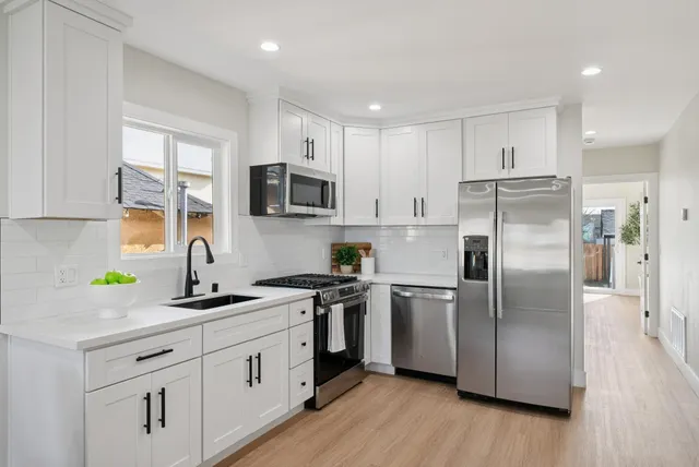 a kitchen with stainless steel appliances a refrigerator sink and microwave