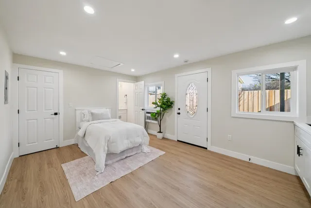 a spacious bedroom with a bed and a potted plant