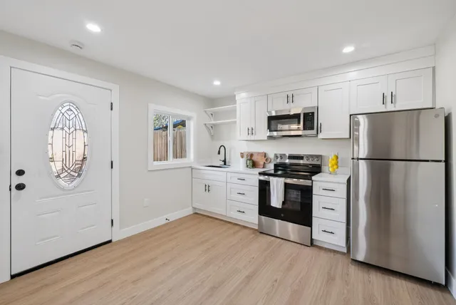 a kitchen with a refrigerator and a stove top oven