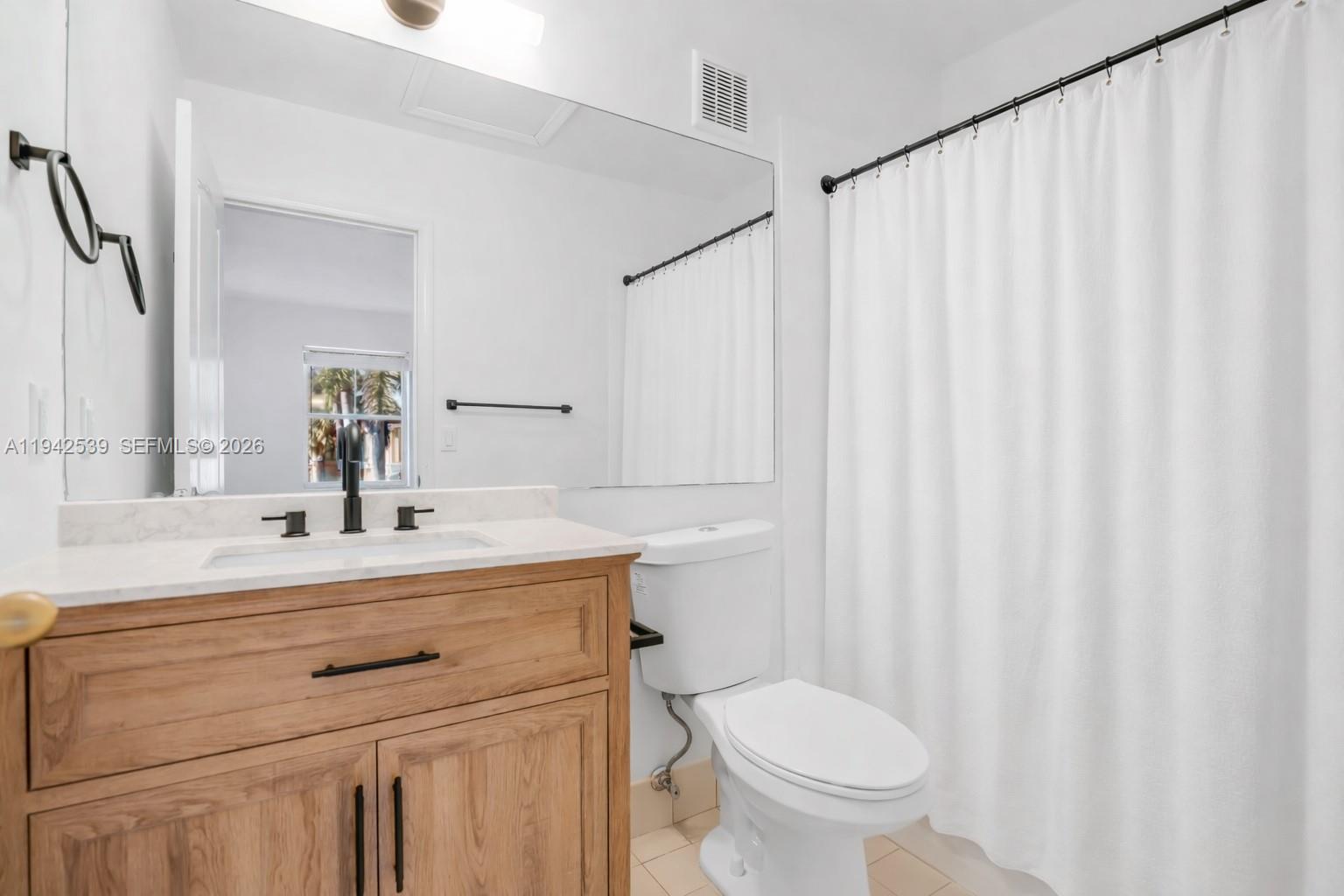 3186 Southwest 129th Terrace, Unit 113 Miramar, FL 33027 - Photo 14 of 29 a bathroom with a sink a toilet and a mirror