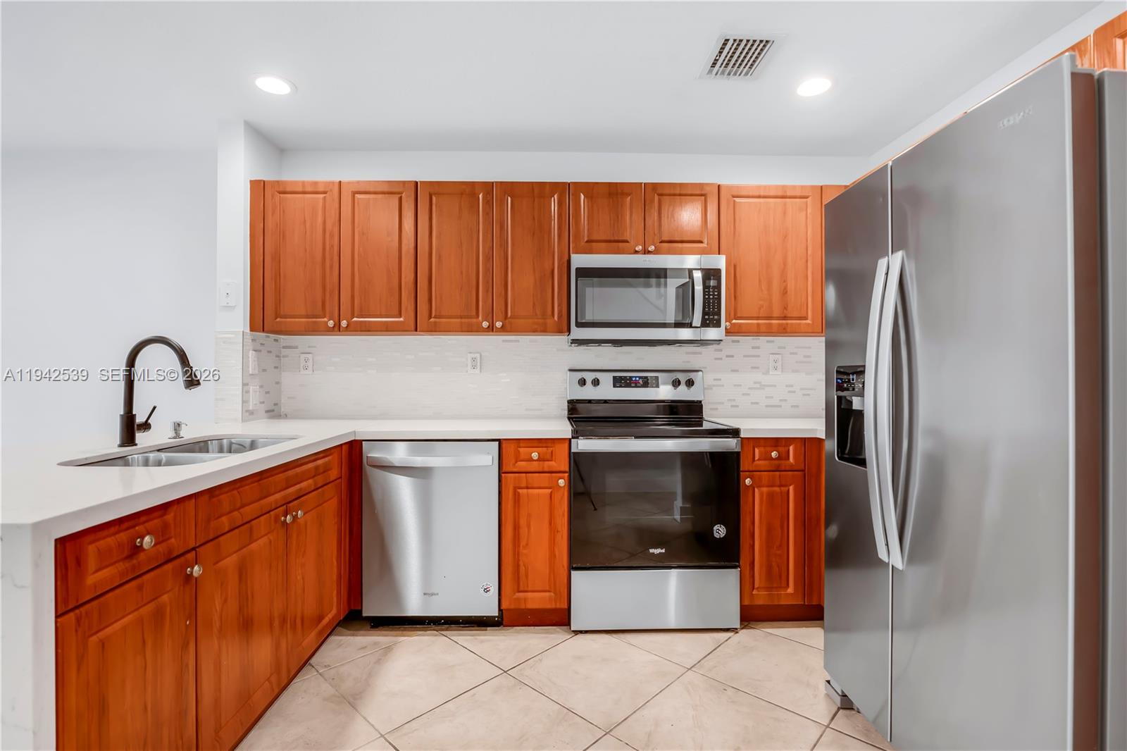 3186 Southwest 129th Terrace, Unit 113 Miramar, FL 33027 - Photo 2 of 29 a kitchen with stainless steel appliances granite countertop a refrigerator and a stove top oven