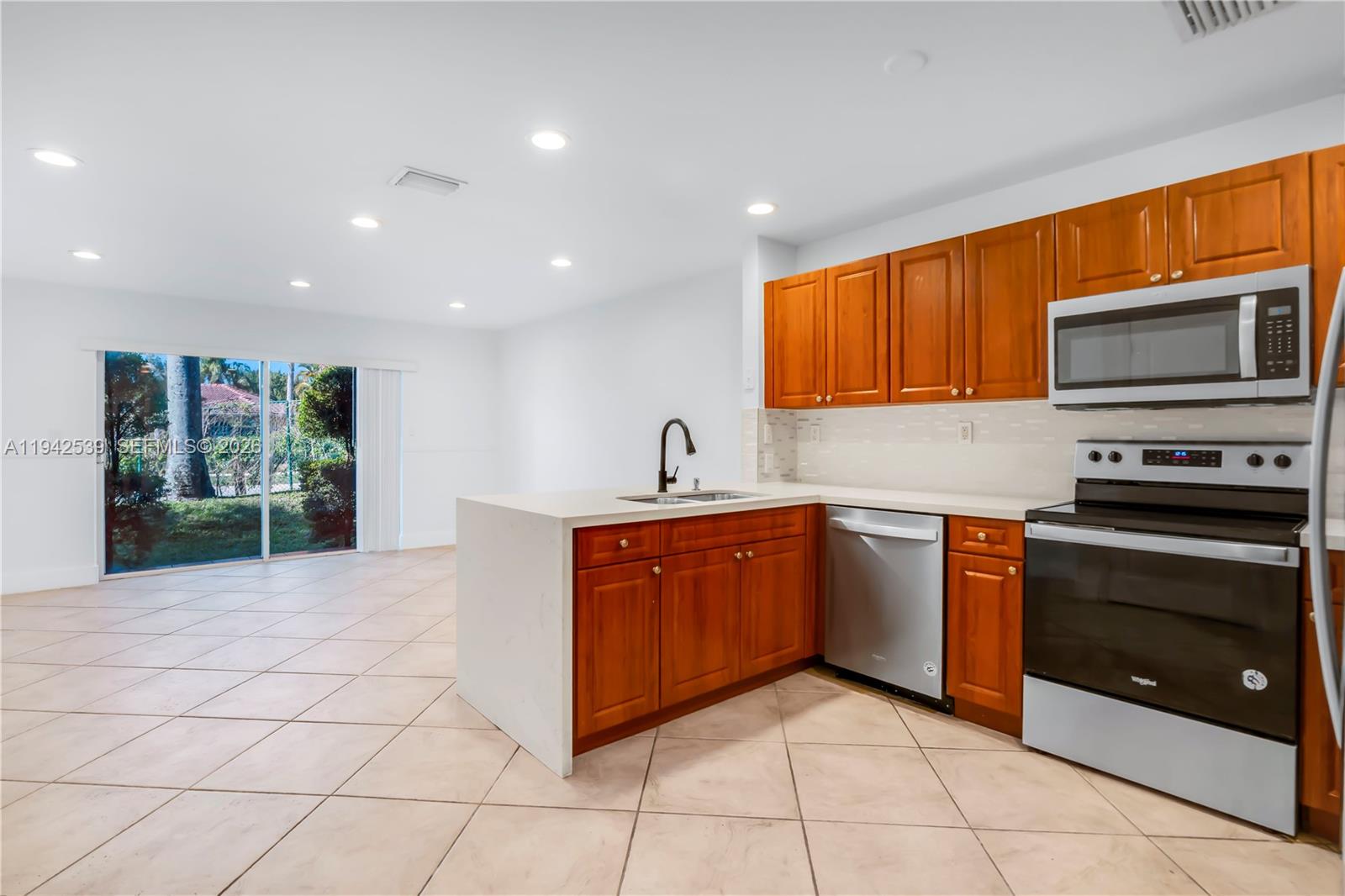 3186 Southwest 129th Terrace, Unit 113 Miramar, FL 33027 - Photo 3 of 29 a kitchen with stainless steel appliances granite countertop a stove and a sink