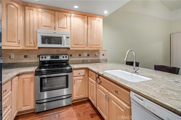 a kitchen with granite countertop a sink stainless steel appliances and cabinets