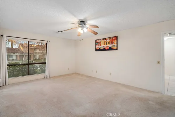 an empty room with windows and fan