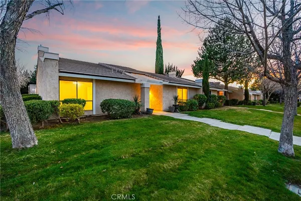 a view of a house with a big yard and a large tree