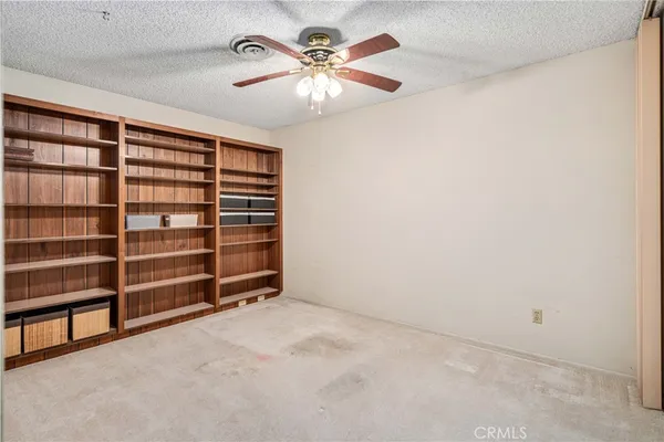a view of an empty room with a ceiling fan and a window