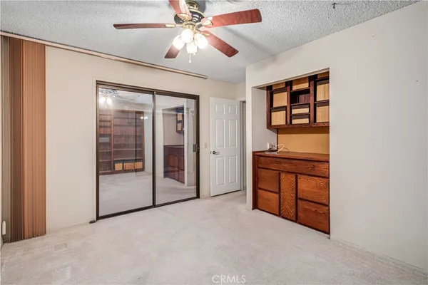 an empty room with windows and ceiling fan