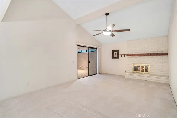 a view of a room with a ceiling fan and a rug