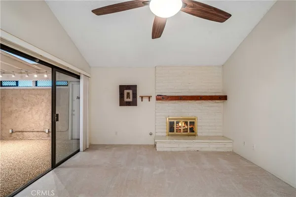 a view of an empty room with a fireplace and a window