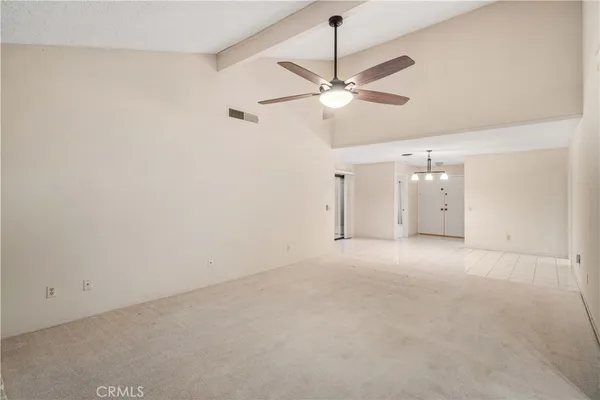 an empty room with a fan & a ceiling fan