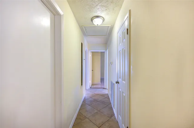 a view of a hallway with wooden floor and a door
