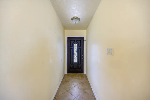 a view of an entryway door with a hallway